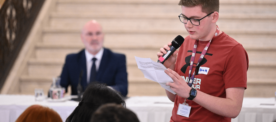 A member (male) of the Youth Assembly making a speech in the Great Hall of Parliament Buildings.