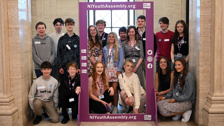 Members of the Youth Assembly posing for a group picture in the Great Hall of Parliament Buildings.
