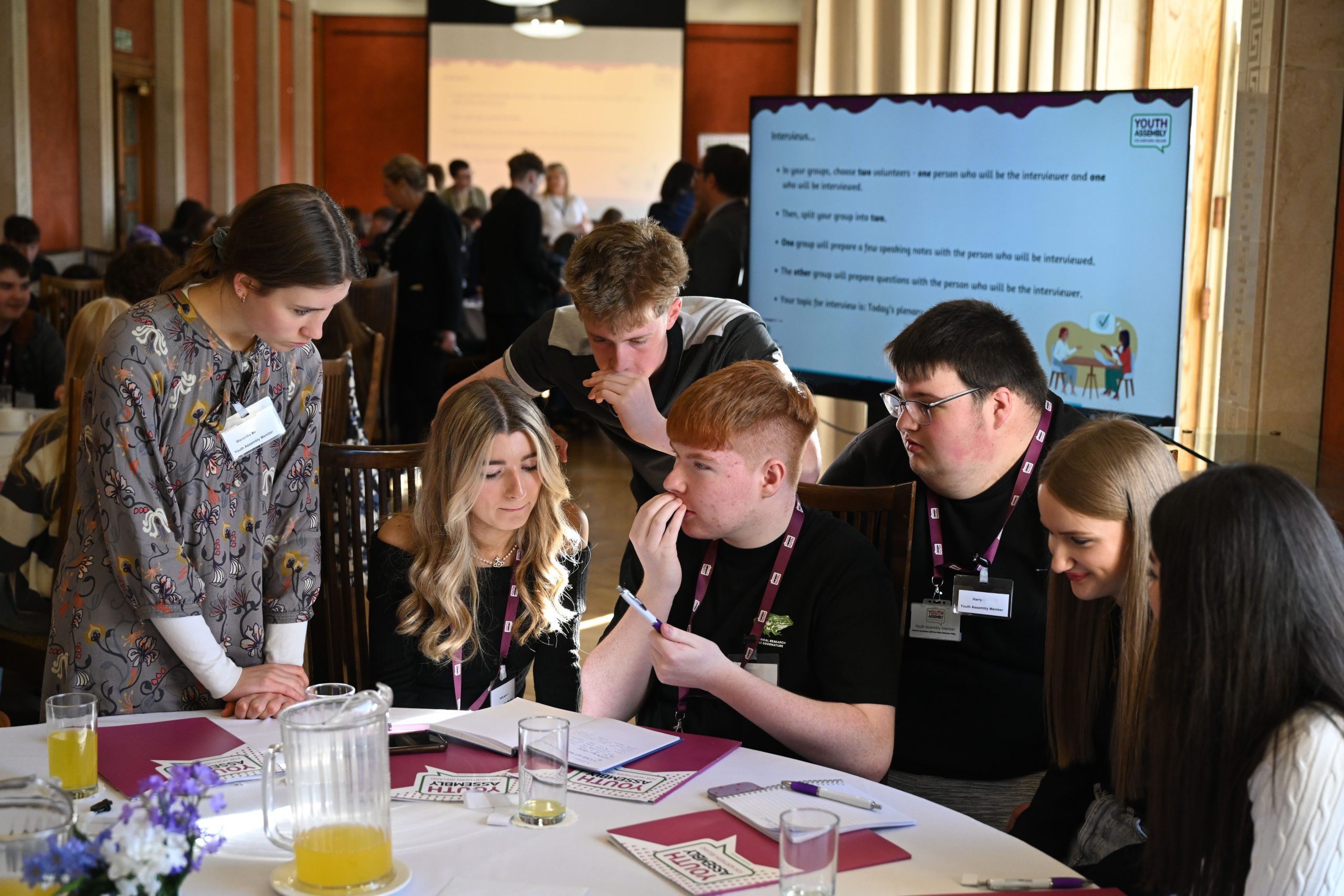 Six youth assembly members working together at a table